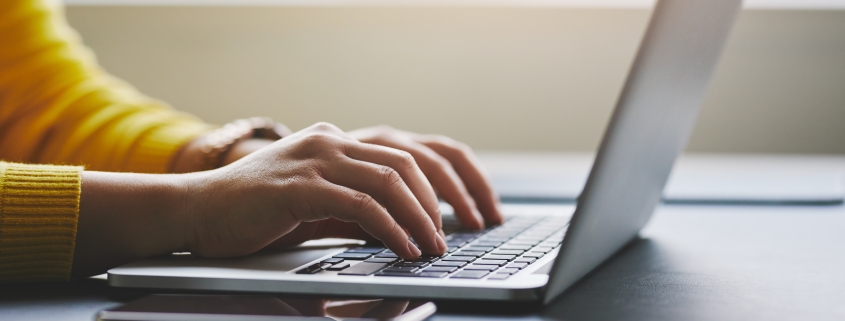 Close up of female hands while typing on laptop